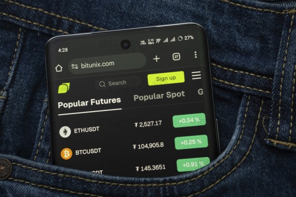 Dhaka, Bangladesh- 15 June 2025: A smartphone displaying the Bitunix.com web interface peeks out of