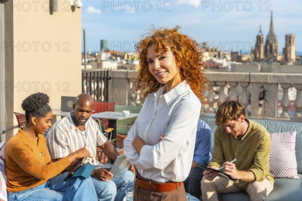 Team of diverse professionals working together on a city rooftop, engaging in discussions and tasks