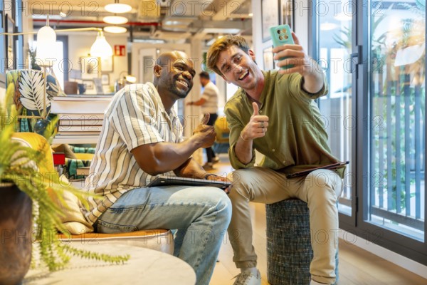 Diverse colleagues enjoying a casual break in a modern coworking space, smiling and giving thumbs