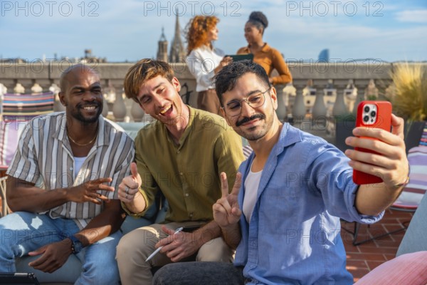 Diverse team of colleagues smiling and taking a rooftop selfie on a sunny urban terrace during a
