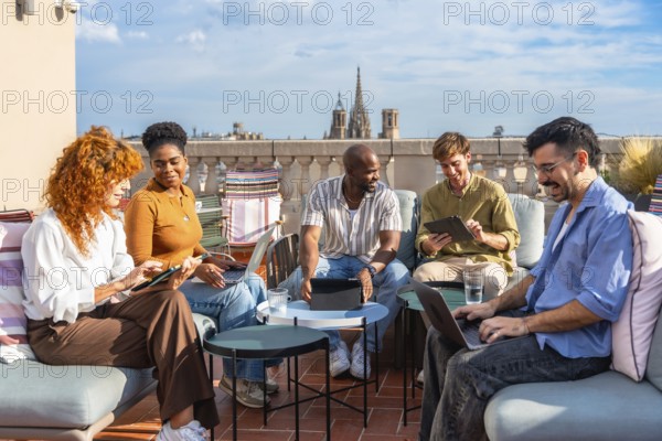 Diverse business colleagues working remotely from an outdoor rooftop office during a break,