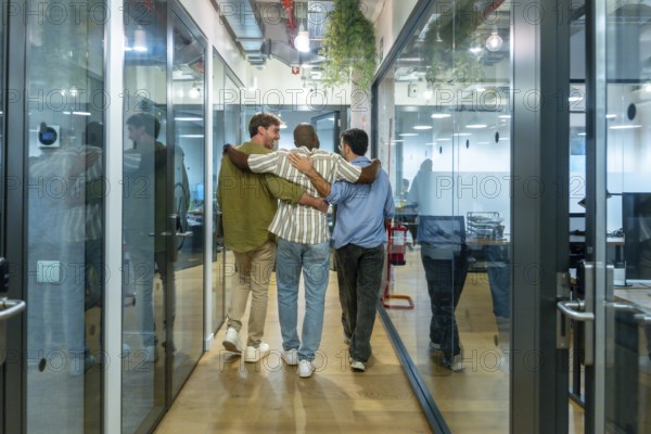 Diverse business colleagues walking together down a modern office corridor, reflecting teamwork,