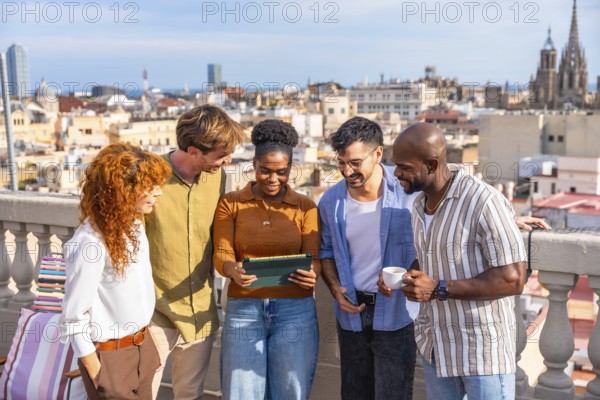 Diverse colleagues networking and smiling on a sunny barcelona rooftop during a casual work break,
