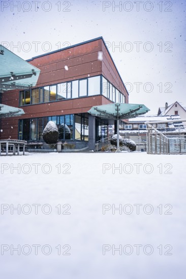 Modern town hall building with glass fronts in a snowy winter landscape, Gechingen, Calw district,