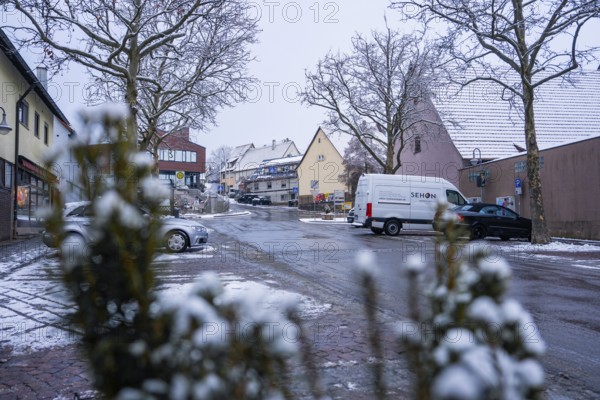 Snowy village road with parked cars and traditional ensemble of houses, Gechingen, Calw district,