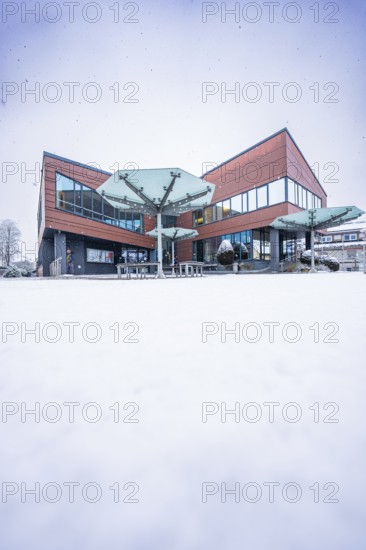 Modern town hall, predominantly glazed building in snowy, wintry surroundings, Gechingen, Calw