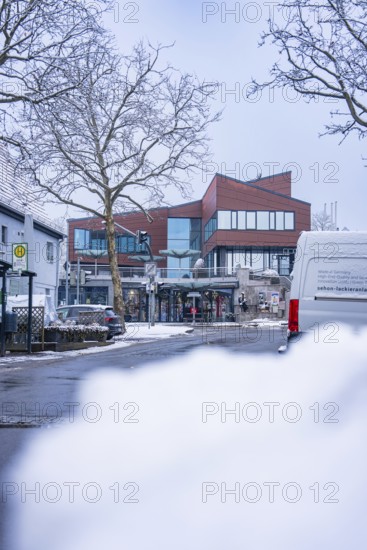 A modern street with snow-covered buildings and cars in winter, Town Hall, Gechingen, Calw