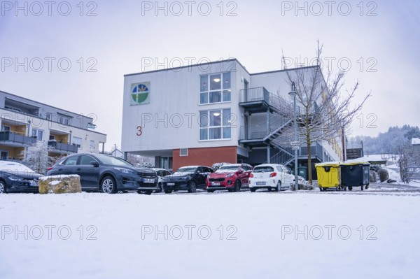 Snowy modern building with parked cars in the foreground in winter, Gechingen retirement home, Calw