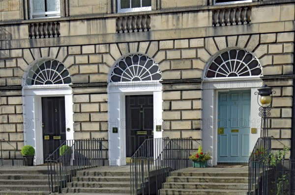 Three Georgian doors with symmetrical windows and stairs in front of them, Newtown, Edinburgh,