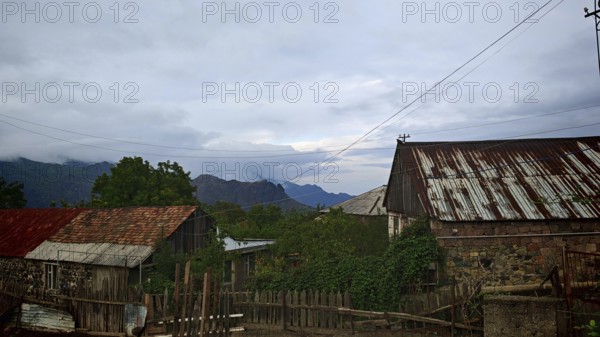 View of a rural village with old houses and mountains in the background, romantic atmosphere,