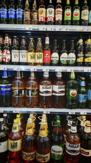 Shelves filled with various beverage bottles, beer selection in a Georgian supermarket, Tbilisi,
