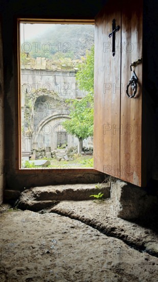An open entrance to a monastery with a view of the old stone structure in the courtyard, Debed