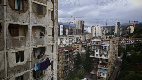 View of an urban landscape, residential district in Tbilisi with high-rise buildings and cranes,