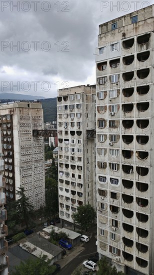 Three high-rise buildings connected by metal bridges under cloudy skies, nostalgic charm,