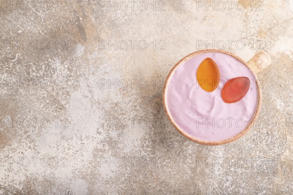 Purple Yogurt, with jelly candy on brown concrete background, top view, flat lay, copy space,