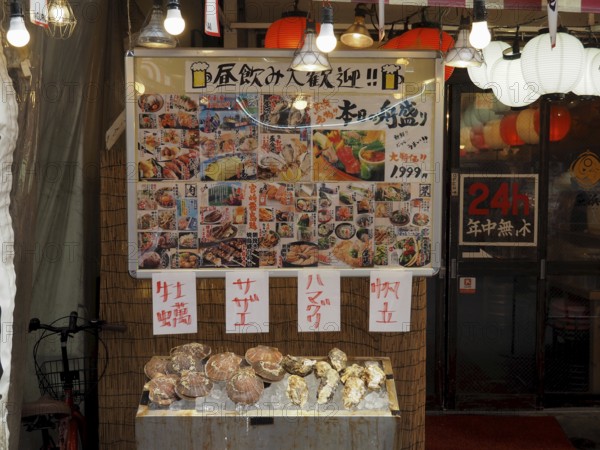Market stand with food and menus on display, decorated with paper lanterns, Ameyoko Market, Tokyo,