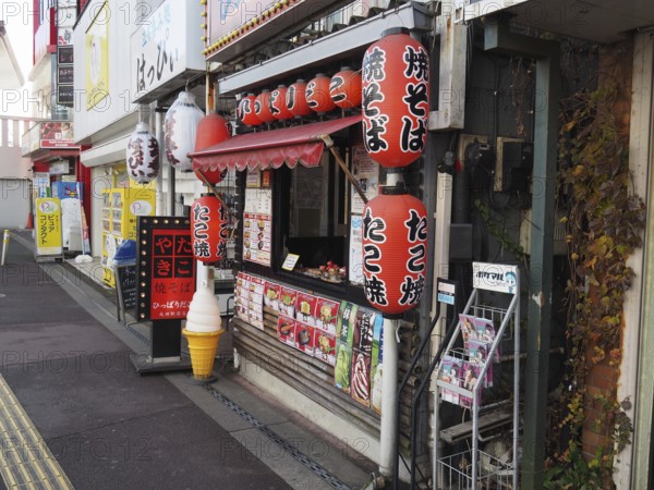 Small Japanese food stand with colorful lanterns on a street, Narita, Japan