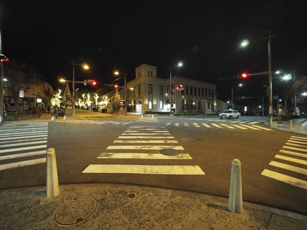 Night view of a quiet and illuminated city intersection with traffic lights, Chuo-dori street,