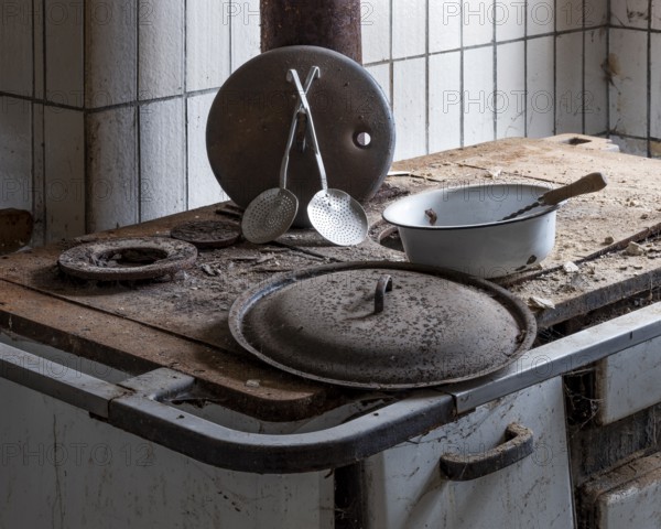 Rusted stove with kitchen appliances in the kitchen in an abandoned country inn, Lost Place,