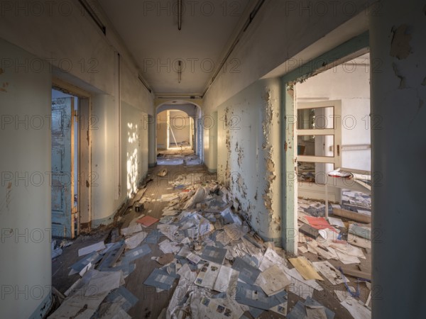 A room and corridor full of files lying around in an abandoned administration building, Lost Place,