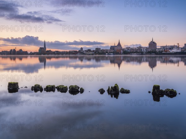 Old town and city port are reflected in the Warnow river, morning scene, Rostock,