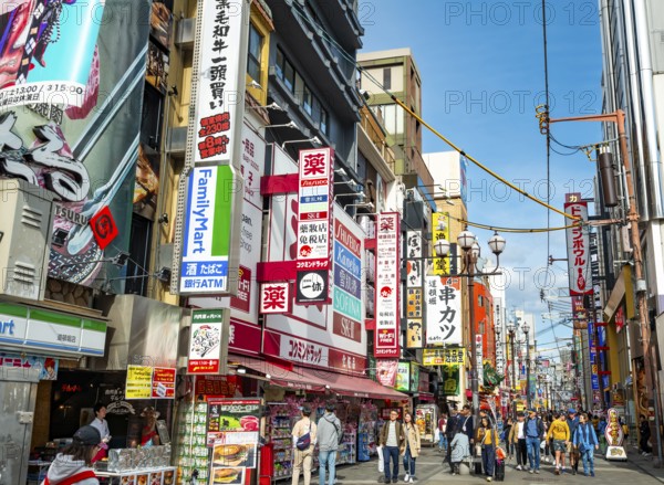 Lots of colorful signs in a pedestrian zone with shops and restaurants, Dotonbori, Osaka, Japan