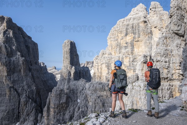 Mountaineers look at Campanile Alto pinnacle, Bocchette Centrale band trail, via ferrata in the
