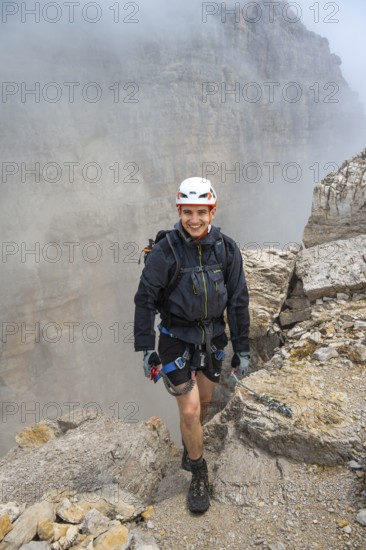 Happy mountaineer, Via Ferrata Oliva Detassis via ferrata in fog, rocky mountain peaks and mountain