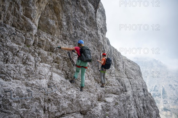 Two mountaineers climbing on rock face, rocky mountain landscape, Via Ferrata SOSAT via ferrata,