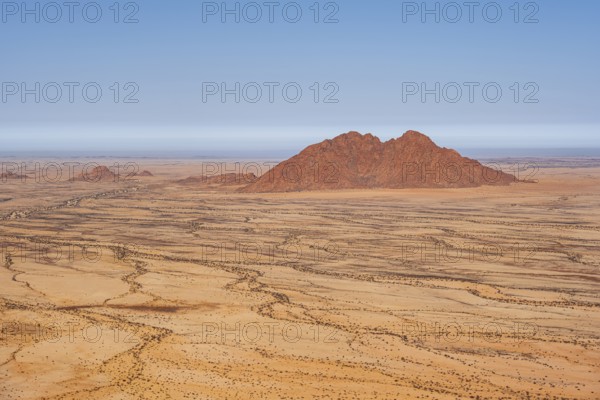 Silhouette of a rocky mountain in the middle of the vast, dry desert landscape, Spitzkoppe, Namibia