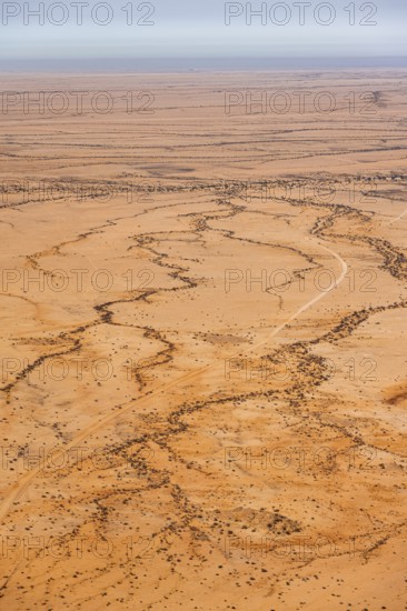 Aerial view of a vast, dry desert with distinctive soil patterns, Spitzkoppe, Namibia