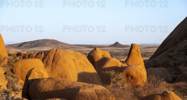 Extensive rock formations and barren desert landscape under clear skies in Spitzkoppe, Spitzkoppe,