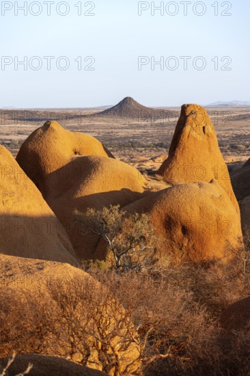 Sun-irradiated rocks offer views of the vast, barren landscape of the Spitzkoppe Desert,