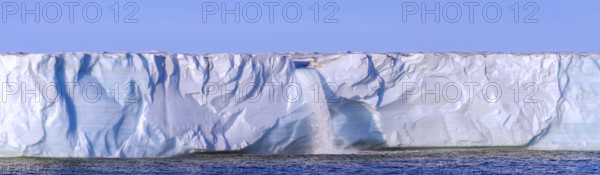 Waterfall at edge of Brasvellbreen glacier from the ice cap Austfonna pouring fresh water into the