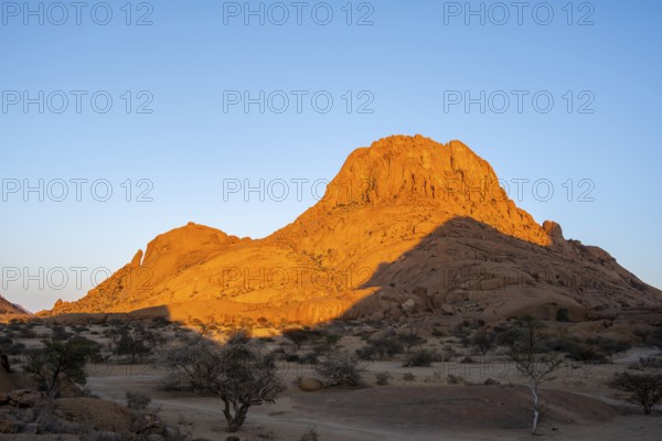 Rocks at sunset in the Namibian desert glow intensely orange, Spitzkoppe, Namibia