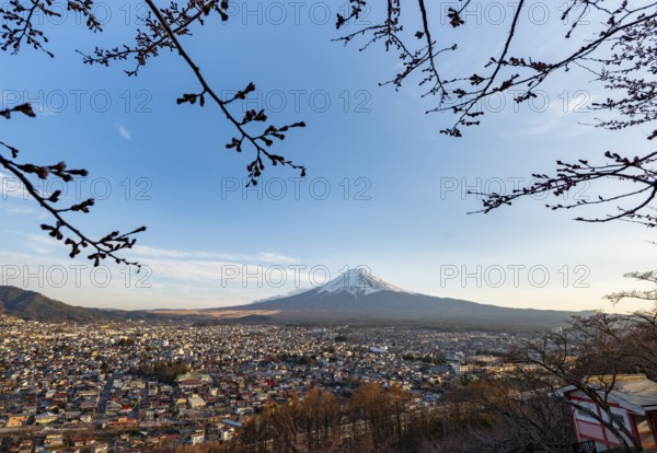 View of Mount Fuji volcano over Fujiyoshida City in evening light, at sunset, Arakurayama Sengen