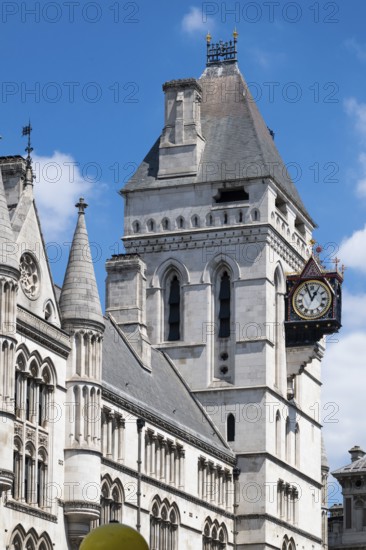 Royal Courts of Justice, neo-gothic architecture with tower and clock under blue sky, London,
