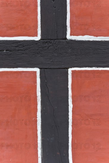 Close-up of a timber-frame structure with red background and black bars, nave, reconstructed