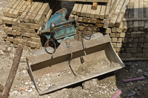 Wooden beam and shovel of an excavator on a construction site