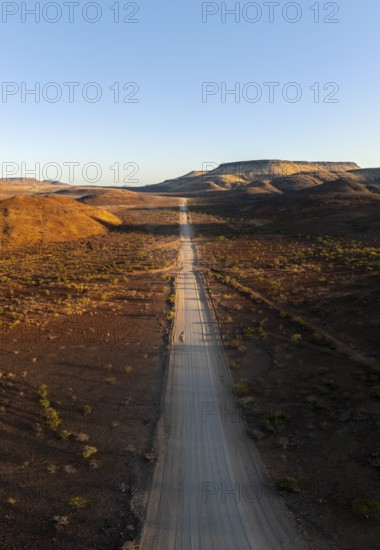 Aerial view, infinite space, straight road leads through dry desert landscape, hills in Damaraland,