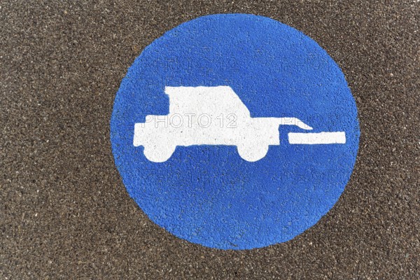 Tractor, front loader, pictogram on the asphalt, agricultural traffic, traffic signs on the dyke,
