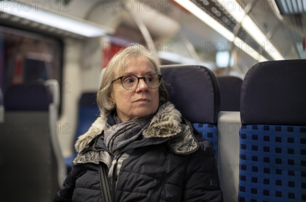 Elderly woman, portrait, thoughtful, glasses, gray hair, coat, scarf, winter clothes, sitting in