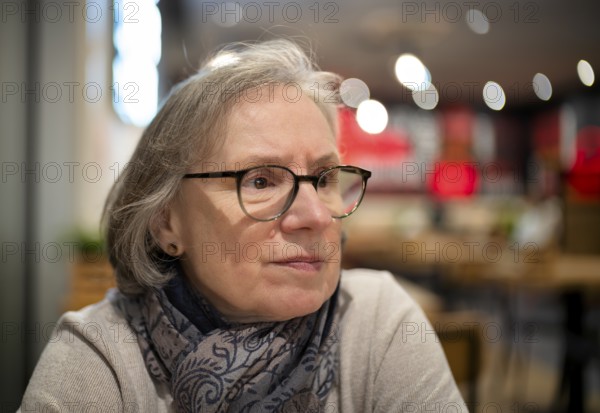 Elderly woman, portrait, glasses, gray hair, scarf, sitting in a bar, restaurant, Stuttgart,
