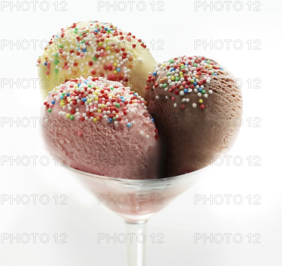 Ice cream sundae with chocolate, strawberry and vanilla, decorated with coloured sprinkles, studio
