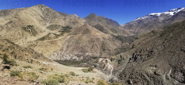 Breathtaking view of a village in a rocky mountain landscape with snow-covered grips under clear