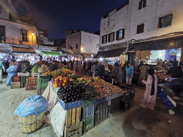Hustle and bustle night market, lots of people and colorful stalls full of fresh produce in the