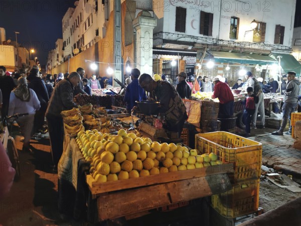 Colourful night market with numerous stalls, illuminated with the hustle and bustle of people in