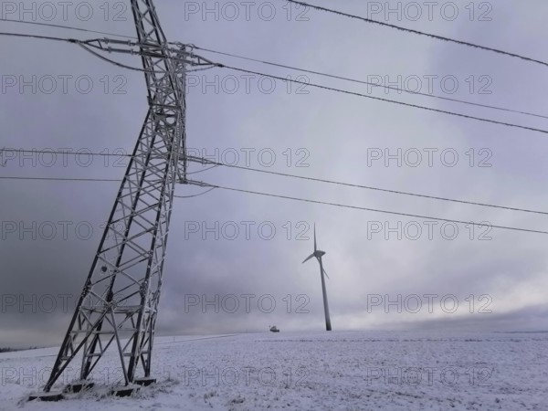 View of a wind turbine and a power pole in a snowy winter landscape, Rennsteig, Frankenwald nature