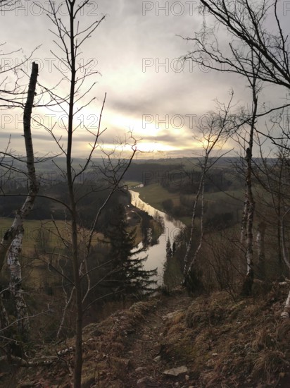 A river snakes through a hilly landscape at sunset, looking across the Saxon Saale from the