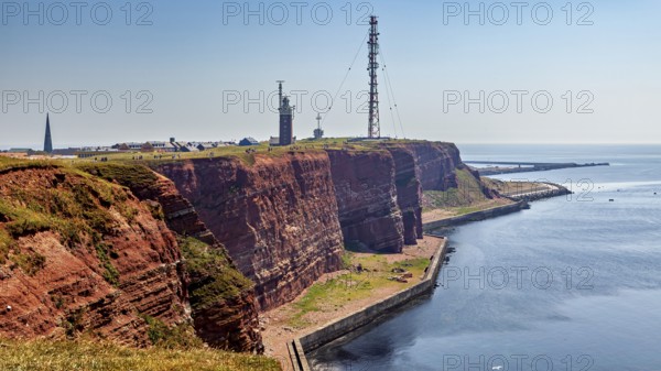 Red cliffs with lighthouse under blue sky on the coast, the high-seas island of Heligoland in the